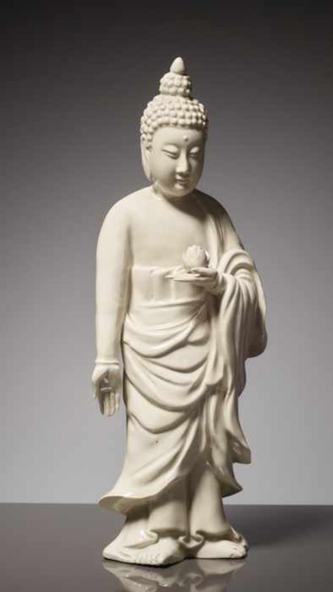 FRÜHE BLANC DE CHINE FIGUR EINES STEHENDEN BUDDHA MIT LOTUSBLÜTE Blanc de Chine-Porzellan, China.