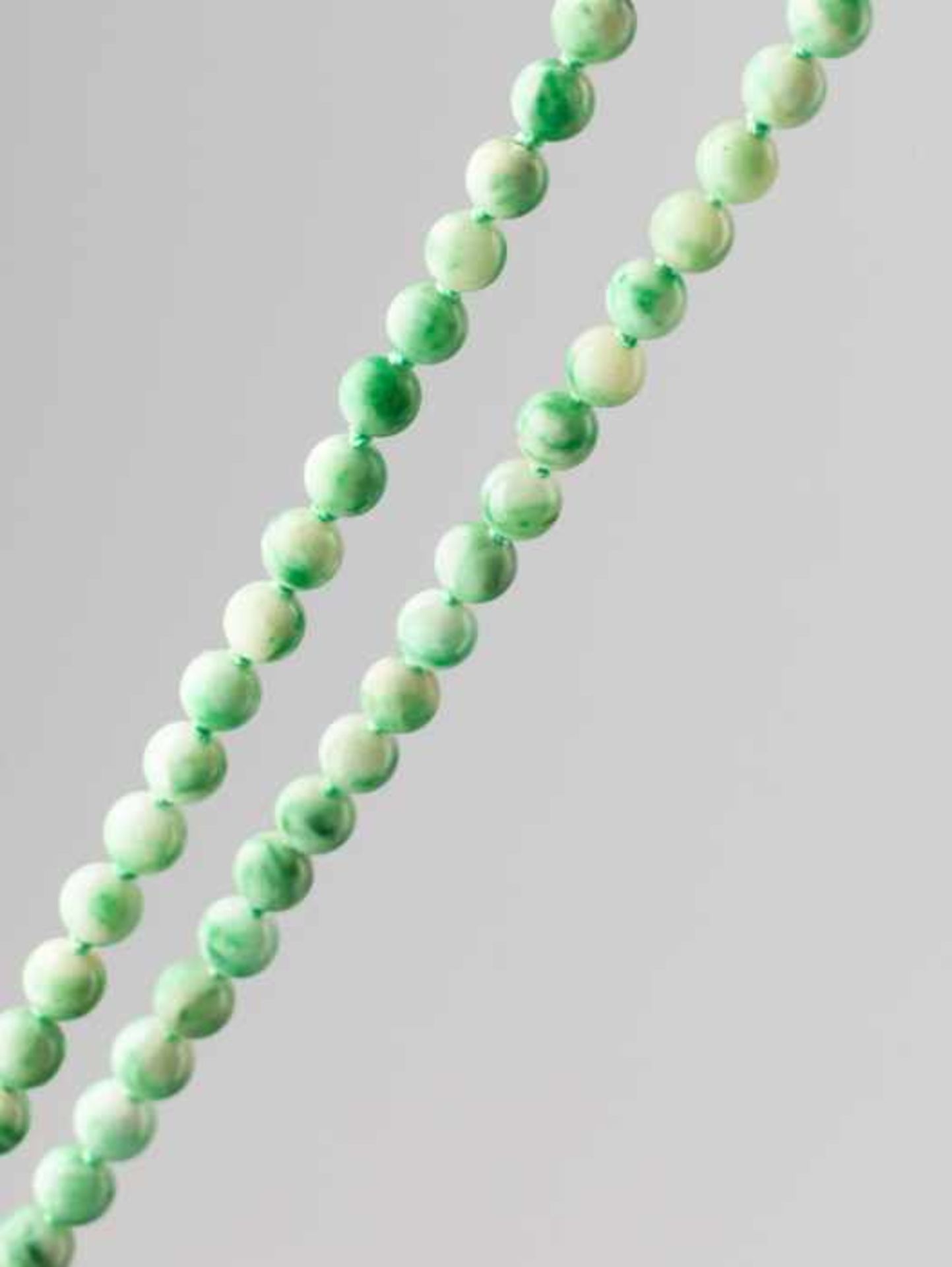 A JADEITE NECKLACE WITH SHADES OF INTENSE EMERALD GREEN, 116 BEADS, QING DYNASTY Natural light green