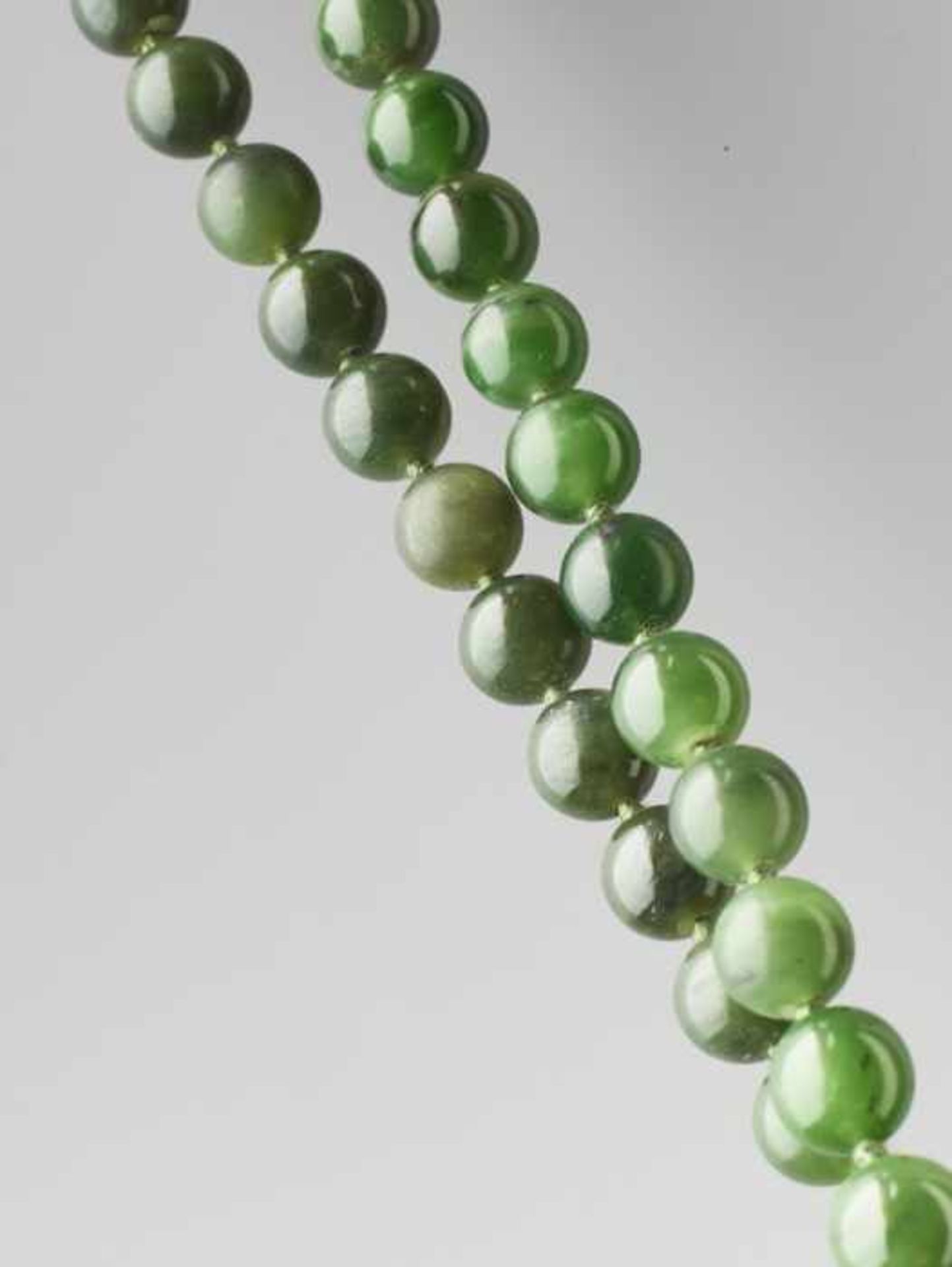 A SPINACH GREEN NEPHRITE BEAD NECKLACE, 71 BEADS, LATE QING DYNASTY Certified natural dark and