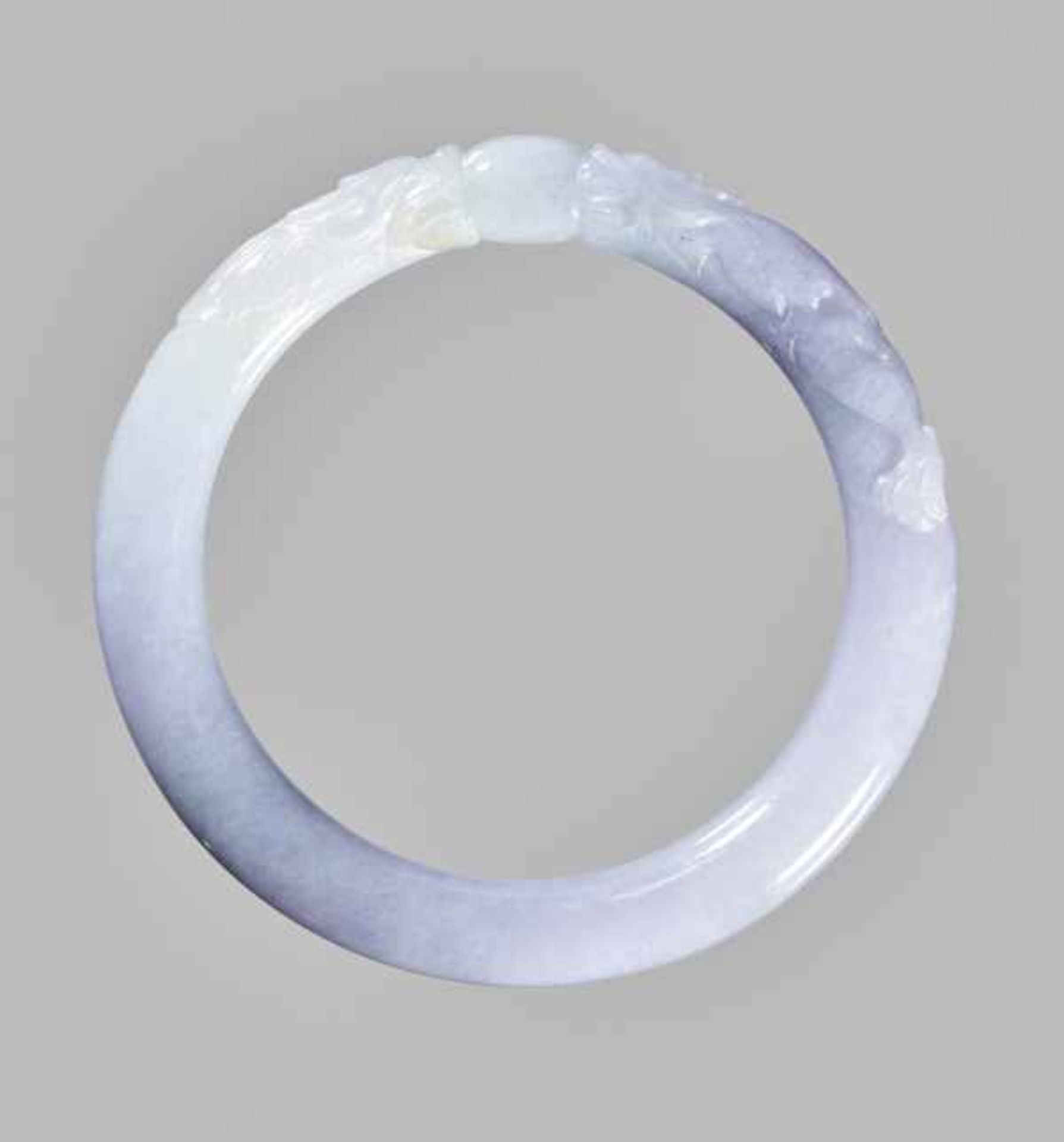 A LAVENDER JADEITE ‘DRAGON AND PEARL’ BANGLE Pale lavender jadeite with cloudy pattern, fine surface