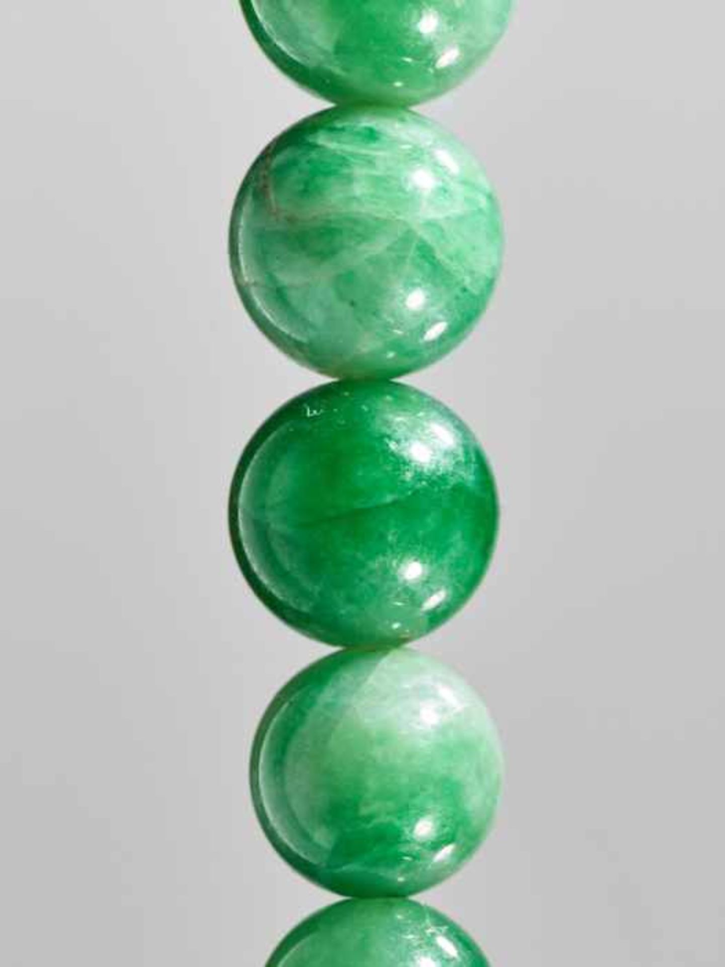 AN EMERALD GREEN JADEITE NECKLACE, 88 BEADS, WITH ORIGINAL SILVER CLASP, QING DYNASTY Emerald