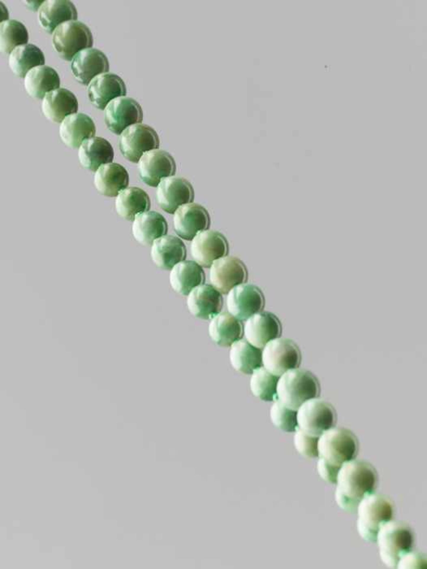 A MOTTLED GREEN JADEITE BEAD NECKLACE, 97 BEADS, LATE QING DYNASTY The natural jadeite beads of