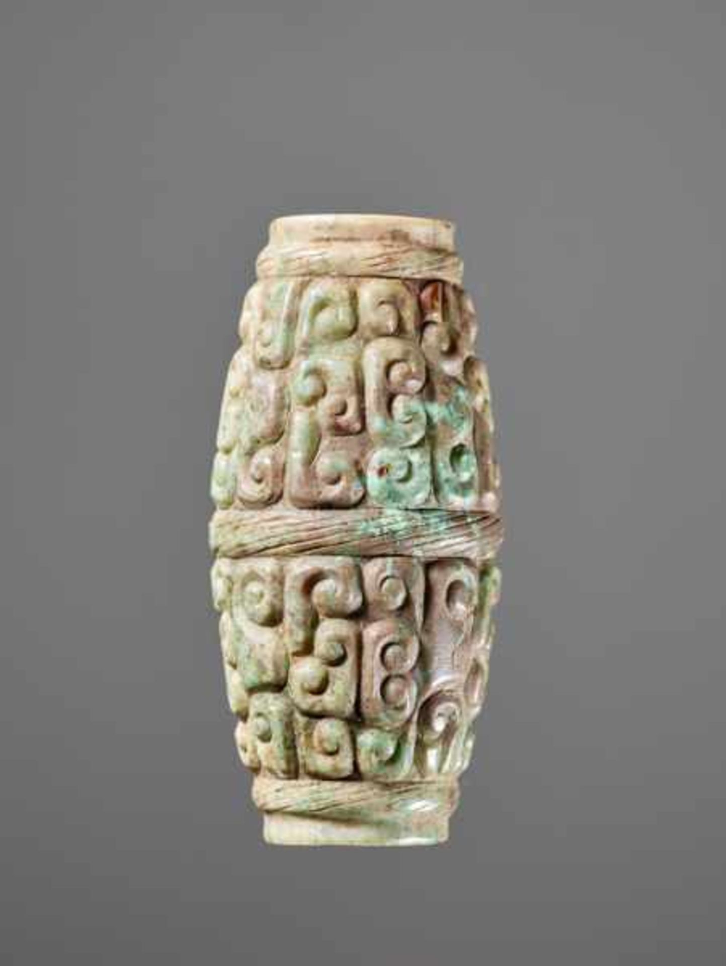 A BARREL-SHAPED BEAD DECORATED WITH THE PANHUI PATTERN OF SWARMING CURLS Jade. China, Eastern