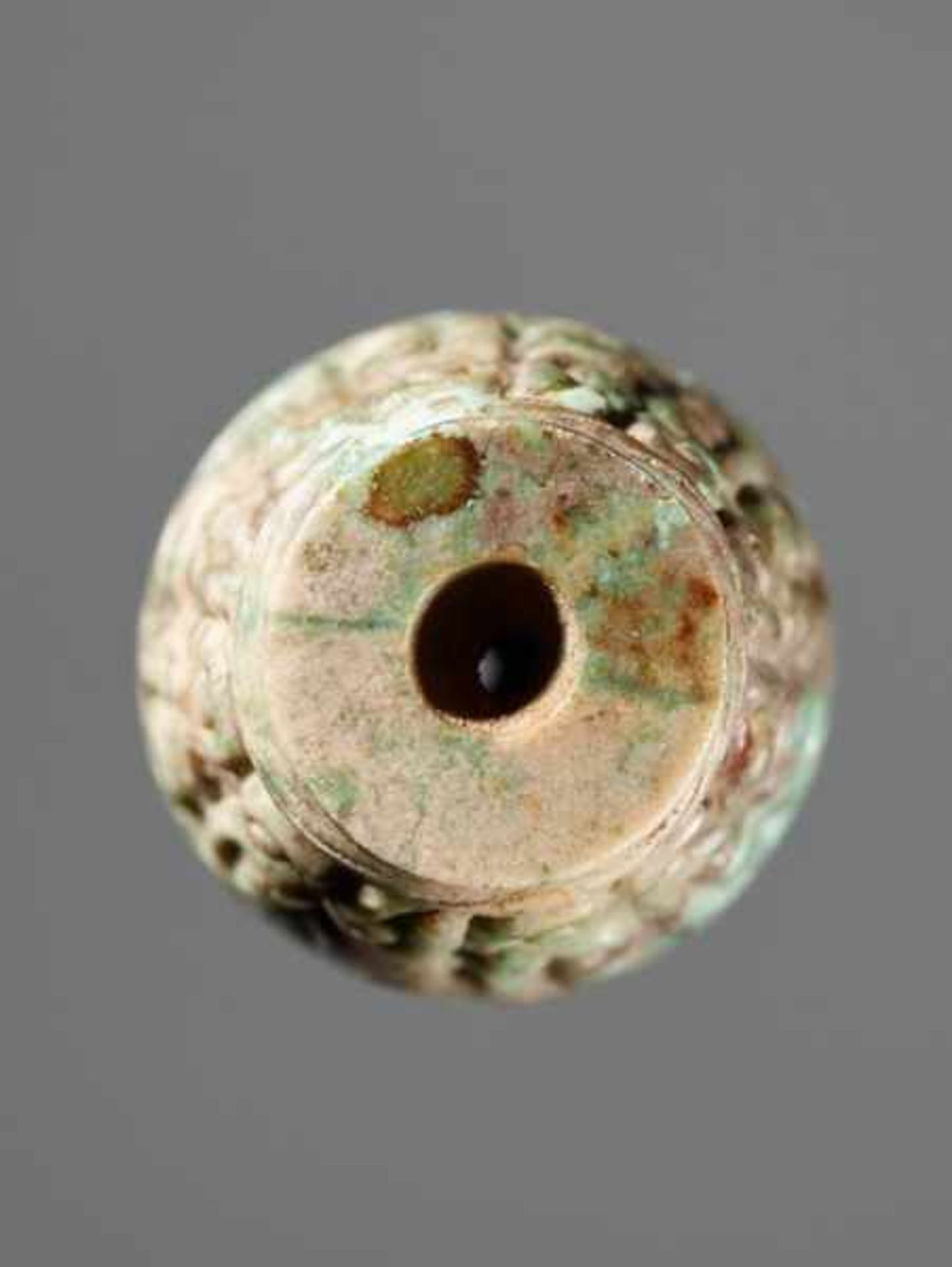 A BARREL-SHAPED BEAD DECORATED WITH THE PANHUI PATTERN OF SWARMING CURLS Jade. China, Eastern - Image 3 of 5