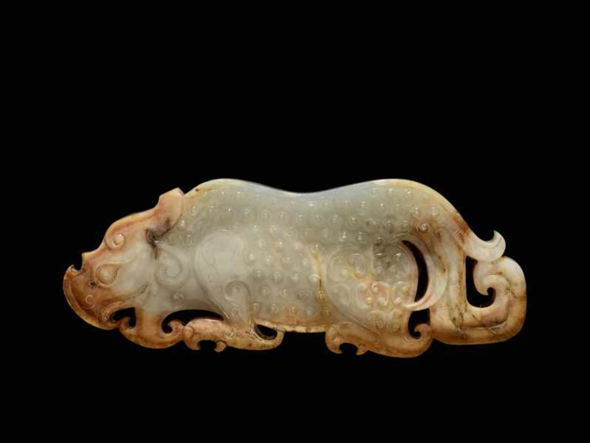 AN EXQUISITE PLAQUE IN WHITE TRANSLUCENT JADE FINELY CARVED IN THE SHAPE OF A CROUCHING TIGER