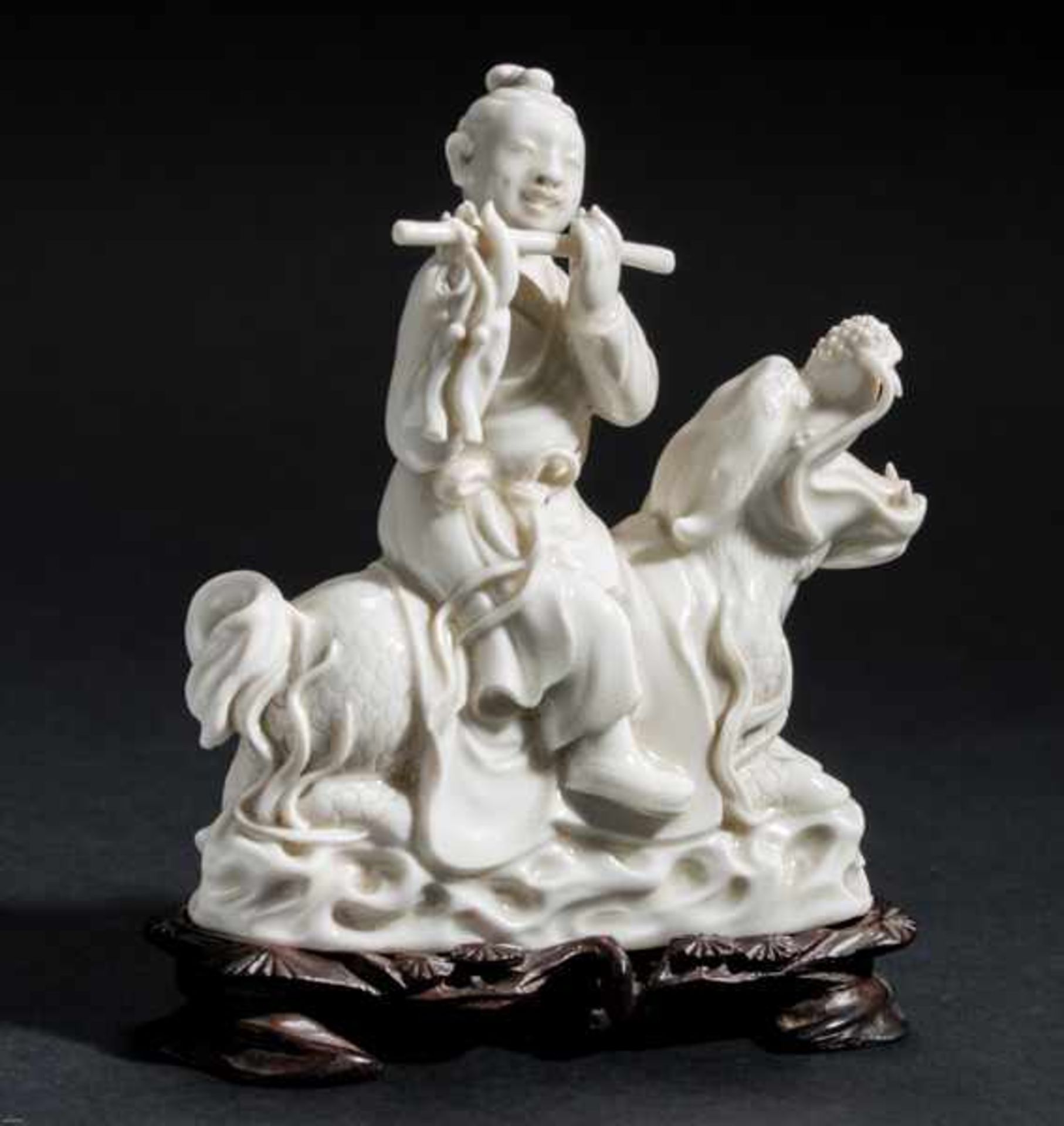 IMMORTAL PLAYING FLUTE Blanc de Chine porcelain. China, Dehua, RepublicHan Xiangzi sitting on a