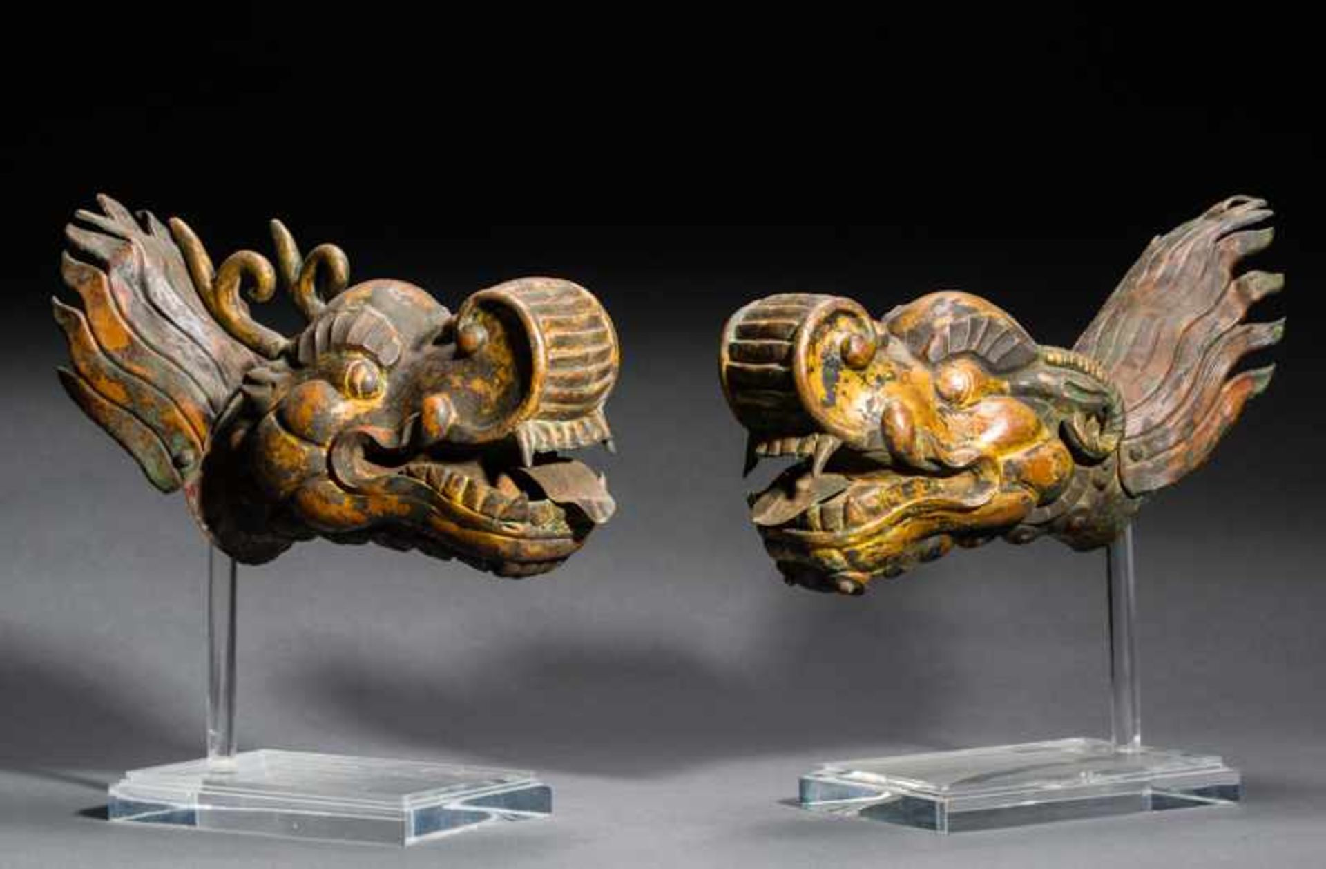 EXPRESSIVE PAIR OF OF MAKARA-HEADS Copper repoussé with gilding. Tibet, ca. 18th cent. / 19 cent.