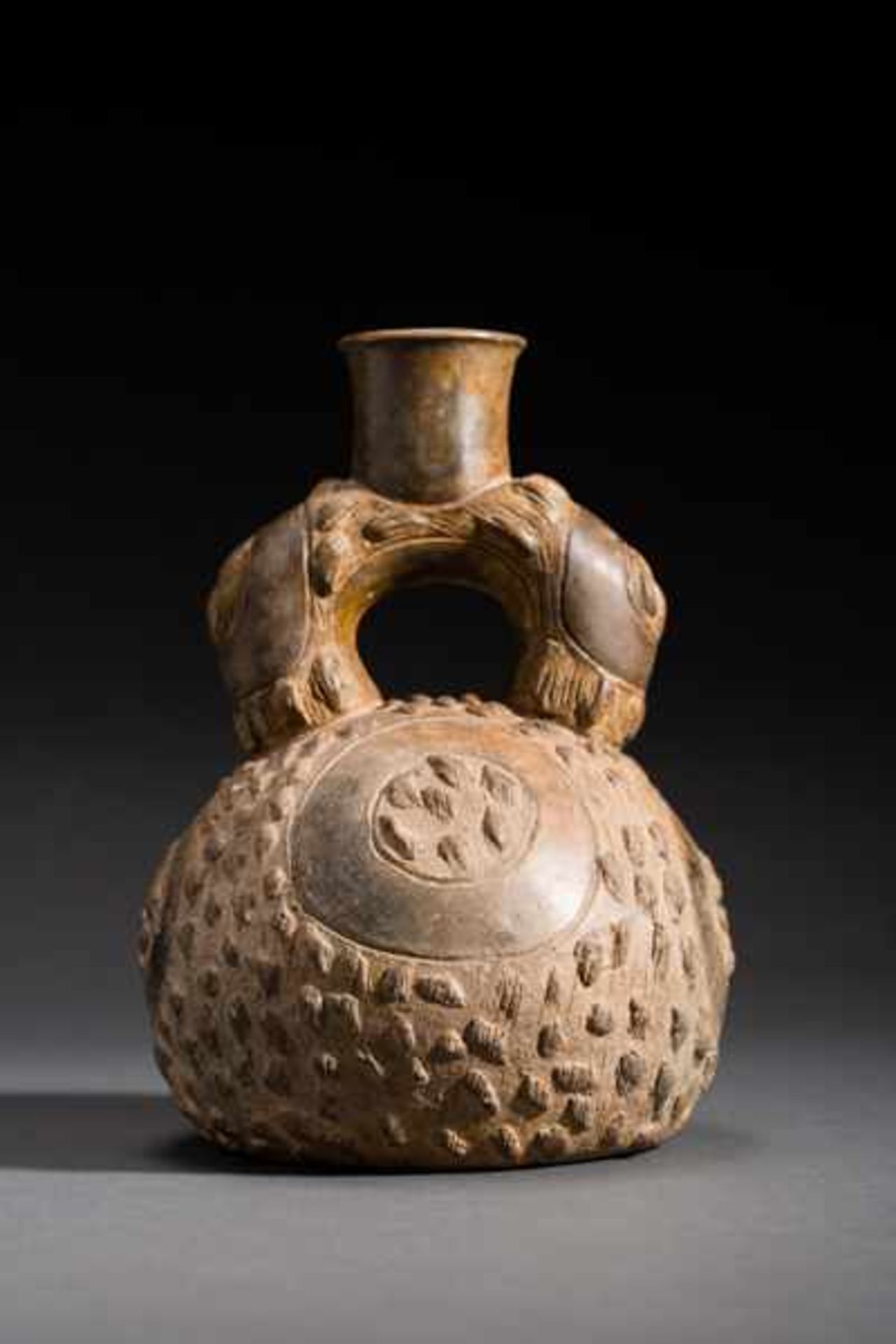 STIRRUP VESSEL WITH ETCHING AND NUBBED DECORATION Terracotta. Chavin, ca. 500 anteSpherical vessel