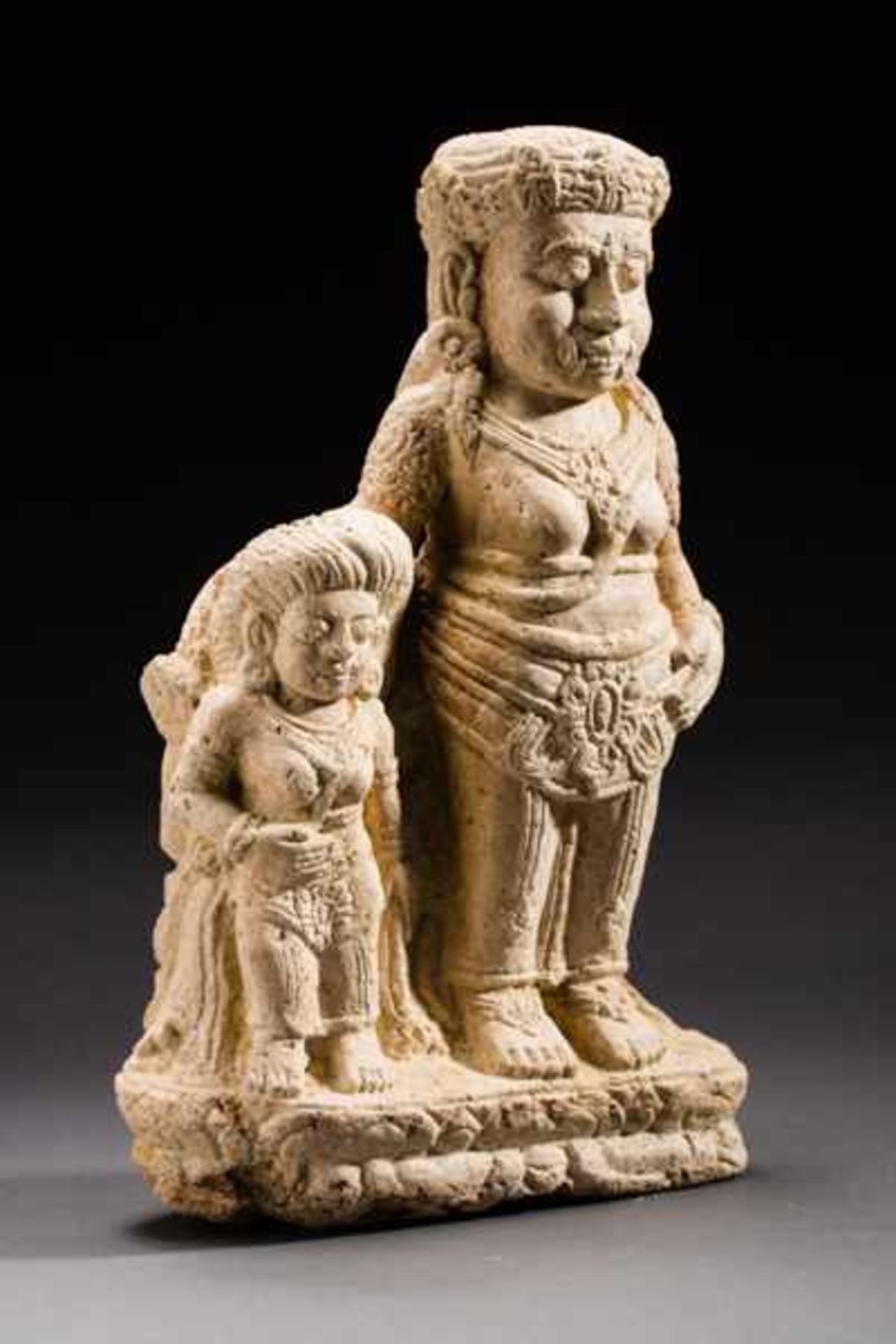 DEMON WITH FEMALE COMPANION Tuff. Majapahit, 14th to 15th cent.This very rare stele also features