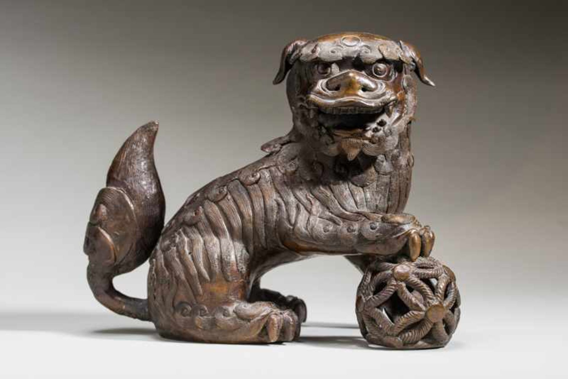 SMOKING VESSEL IN THE SHAPE OF A LION-DOG WITH BALL Bronze. China, Qing dynasty, ca. 18th to 19th