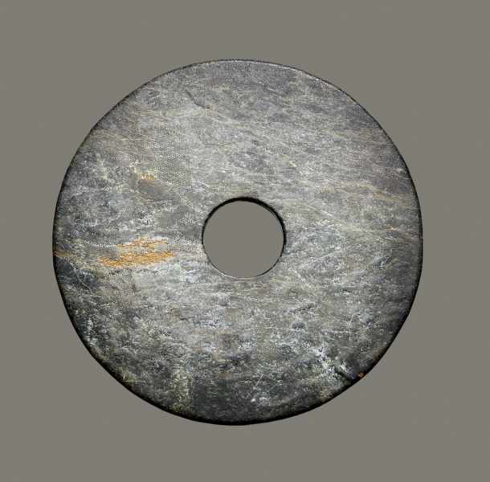 BI-DISC Jade. China, late Neolithic to Bronze Age, c. 2000 to 1500 BCThe mineral black-green in