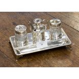 A George III silver inkstand, Empire style with two vessels on a tray supported on four feet,