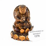 An Oriental carved ivory figure of a Buddha sitting on a lotus leaf,