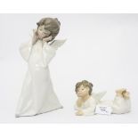 Two Lladro angel figures, one reclining, one standing,