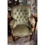 A Victorian deep buttoned armchair with scrolled arm supports, padded arm rests,