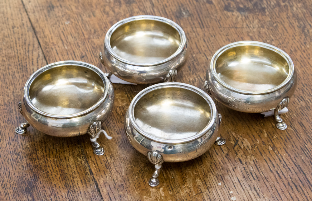A set of four Victorian silver circular salts, raised on three acanthus capped hoof feet,