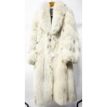 A full length cream Arctic Fox fur coat, lined in grey embroidered lining, worn on cuffs,