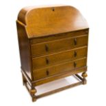 An Art Deco oak bureau, cushion moulded fall front opening to reveal a pigeon holed interior,