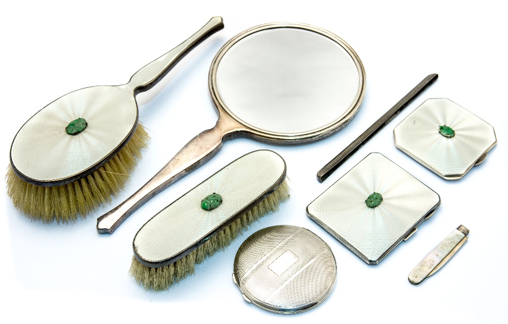 An Art Deco enamelled silver and jade vanity set, including hand mirror, brushes, cigarette case,