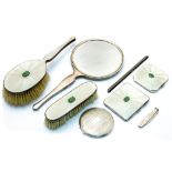 An Art Deco enamelled silver and jade vanity set, including hand mirror, brushes, cigarette case,