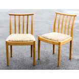 A set of four Ercol light oak dining chairs, shaped, vertically slatted backs, circa 2001,