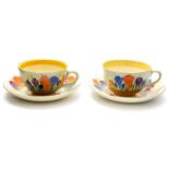 Clarice Cliff for Wilkinson and Newport Pottery, two Crocus pattern tea cups and saucers,