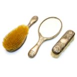 An Art Nouveau silver brush and mirror set, embossed with sinuous floral and vine design,