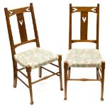 A pair of Arts and Crafts oak chairs, probably Liberty and Co.