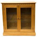 An Ercol light elm and ash glazed display cabinet bookcase, with glass shelves,