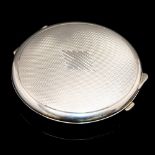 An Art Deco silver compact, circular form, engine turned with stepped baton diamond to the centre,