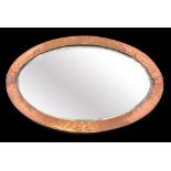 An oval Arts and Crafts mirror, hammered copper frame,