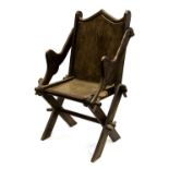 A Gothic Revival oak Glastonbury chair, with ogee arched back, peg joints,