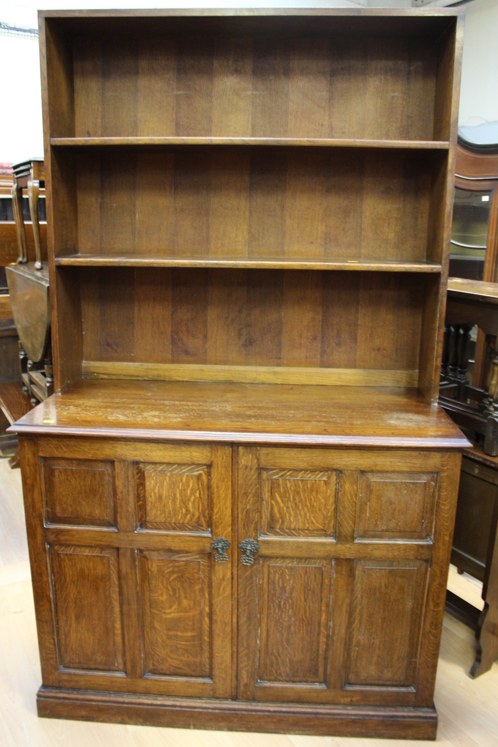 An early 20th Century oak bookshelf, the rack with two fitted shelves,