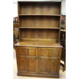 An early 20th Century oak bookshelf, the rack with two fitted shelves,