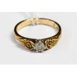 A diamond solitaire 9ct yellow gold ring with rose design shoulders,