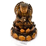 An Oriental carved ivory figure of a Buddha sitting on a lotus leaf,