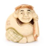 A 19th century Japanese carved ivory polychrome netsuke, in the form of man holding a sack,