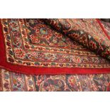 Large red ground Persian Kashan carpet with traditional medallion design