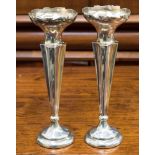 A pair of weighted silver tapered stem vases with floral decoration to open bowl-shaped neck,