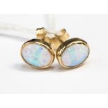 A pair of synthetic opal ear studs in yellow gold,