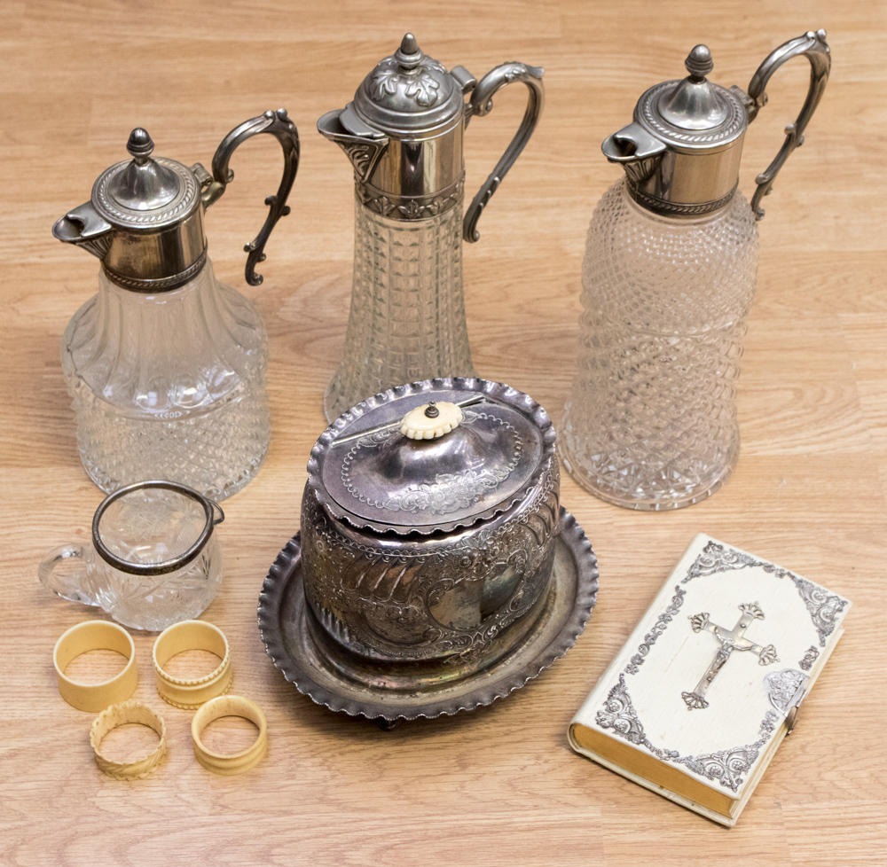 Three silver plated topped decanters, a silver plated tea caddy on stand, ivorine bible,