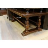 A solid oak coffee table, the top raised on square legs,