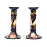 A pair of Moorcroft Peach and Fig pattern candlesticks, measuring approx 21 cm high, dated 2000,