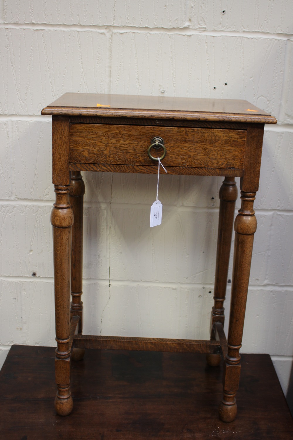 A traditionally made oak side table, fitted with a single drawer and standing on turned legs,
