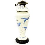 A milk glass, and blue enamel oil lamp base with wick fittings, on stone plinth,