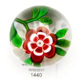 A Baccarat red primrose on clear paperweight, having star cut base,