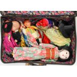 A suitcase with a collection of various dress dolls