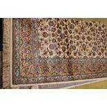 Ivory ground Kashmir rug with all over floral design with unique gold border