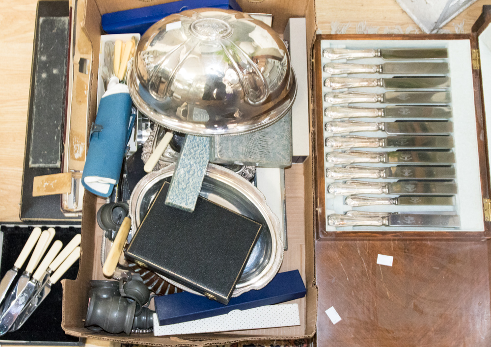 A box containing a collection of various flatware, including teaspoons, serving sets,