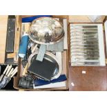 A box containing a collection of various flatware, including teaspoons, serving sets,